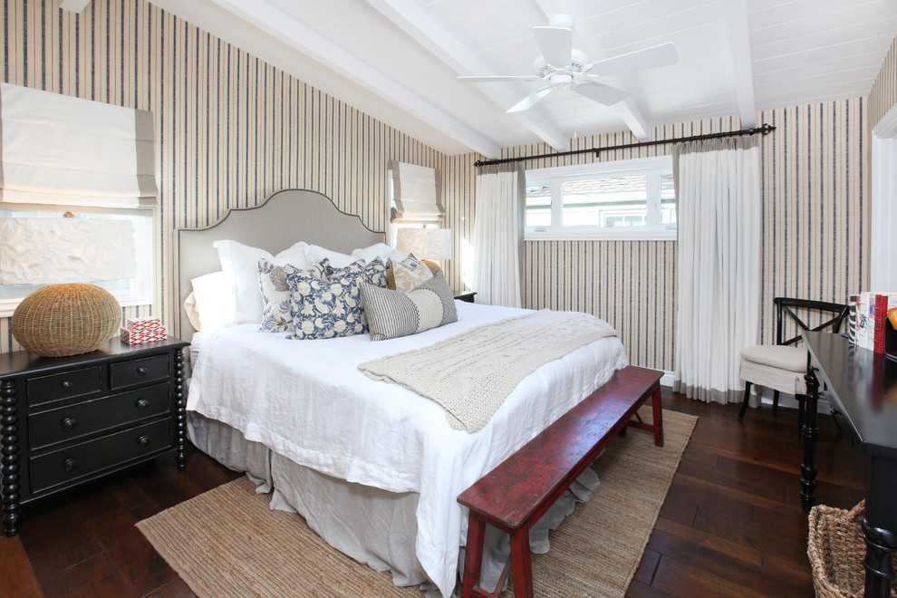 Imagen de dormitorio tropical con paredes multicolor y suelo de madera oscura
