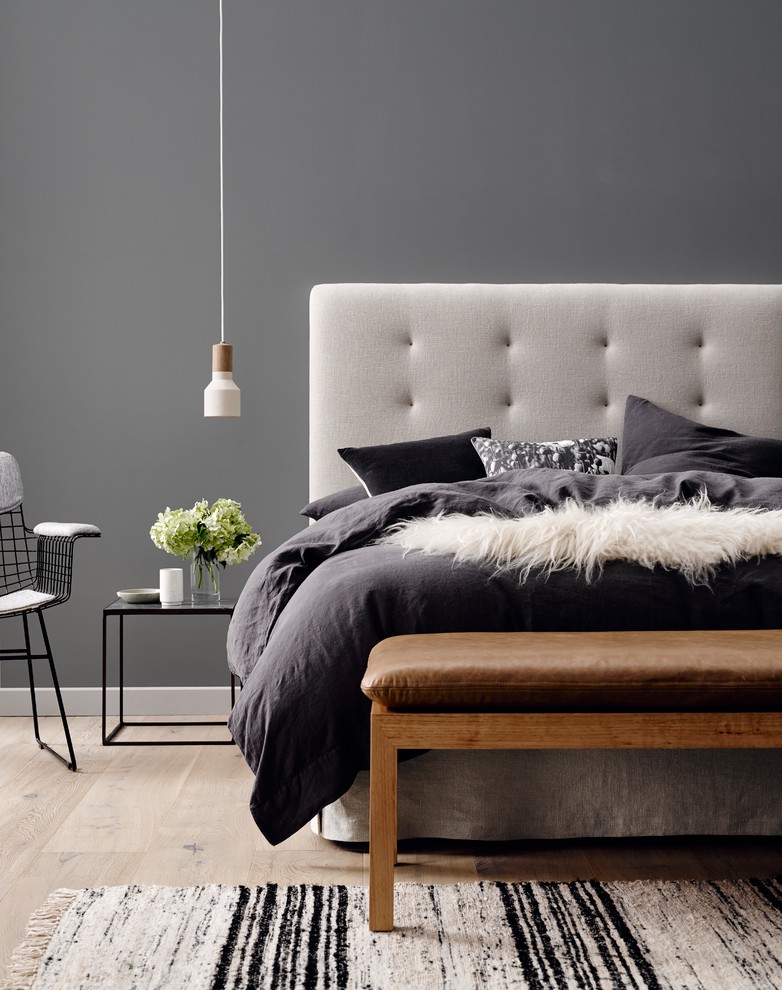 Modelo de dormitorio minimalista con paredes grises y suelo de madera clara