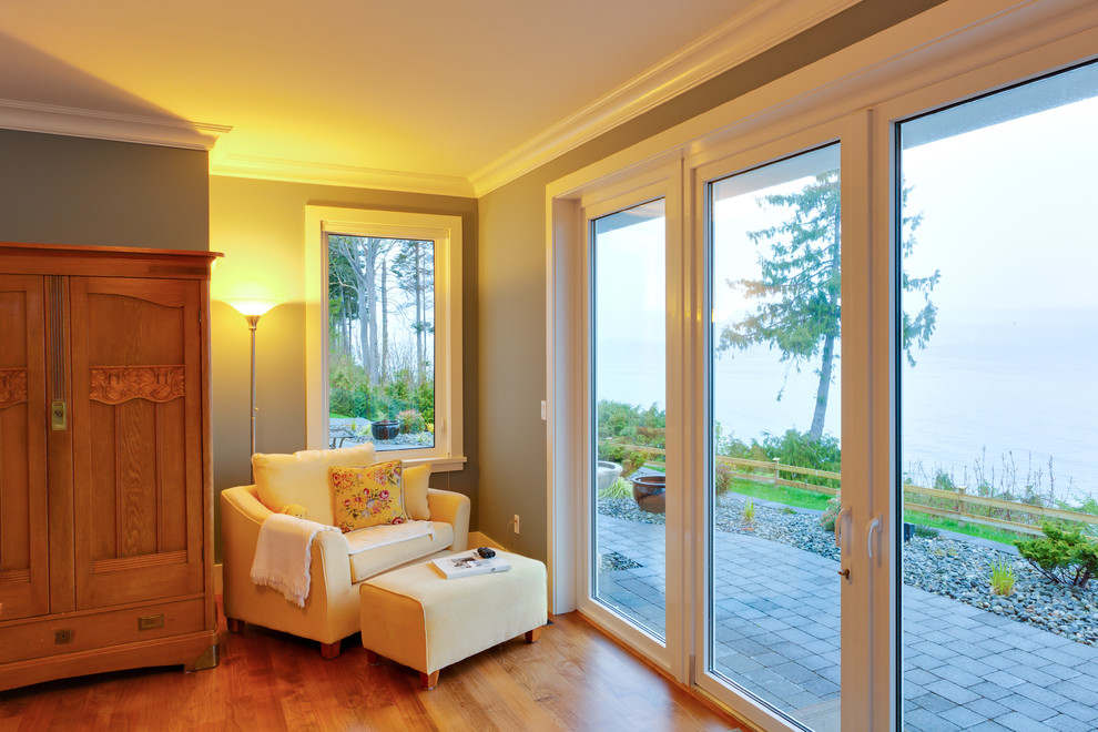 This is an example of a traditional master bedroom in Vancouver with beige walls and medium hardwood flooring.