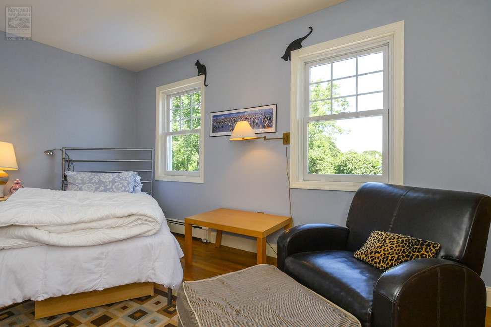 Inspiration pour une chambre d'amis de taille moyenne avec un mur bleu, un sol en bois brun, aucune cheminée et un sol multicolore.