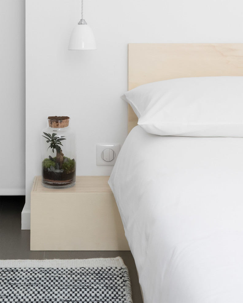 Mittelgroßes Skandinavisches Hauptschlafzimmer mit weißer Wandfarbe, braunem Holzboden und grauem Boden in London