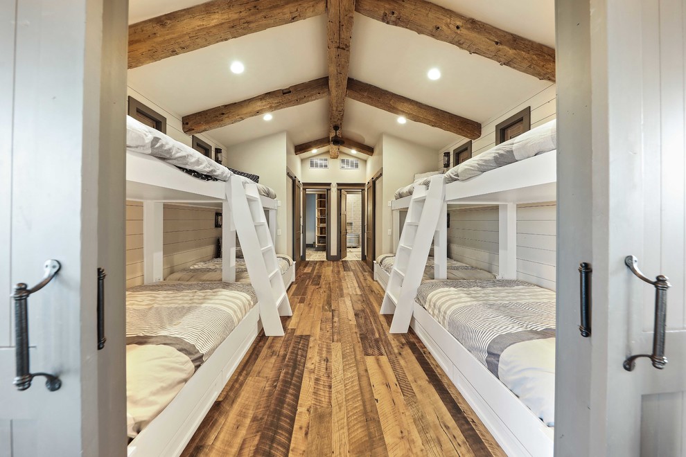 Ejemplo de habitación de invitados campestre con paredes blancas, suelo de madera en tonos medios y suelo marrón