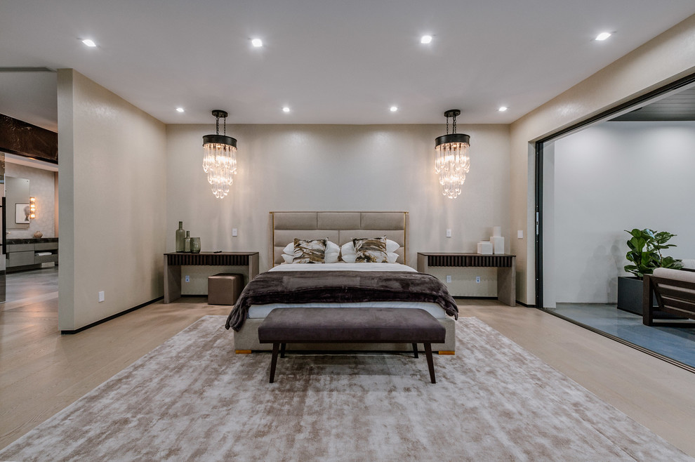 ロサンゼルスにある巨大なコンテンポラリースタイルのおしゃれな主寝室 (グレーの壁、淡色無垢フローリング、横長型暖炉、石材の暖炉まわり) のインテリア
