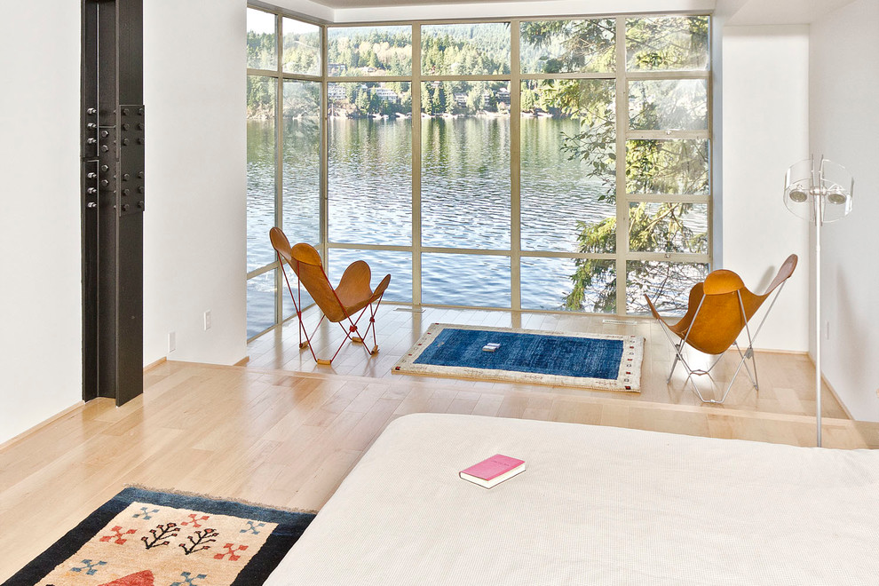 Großes Modernes Schlafzimmer ohne Kamin mit weißer Wandfarbe und hellem Holzboden in Vancouver