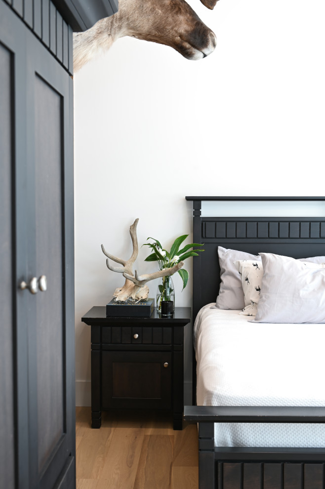 Idee per una camera da letto design con pareti bianche e pavimento in legno massello medio