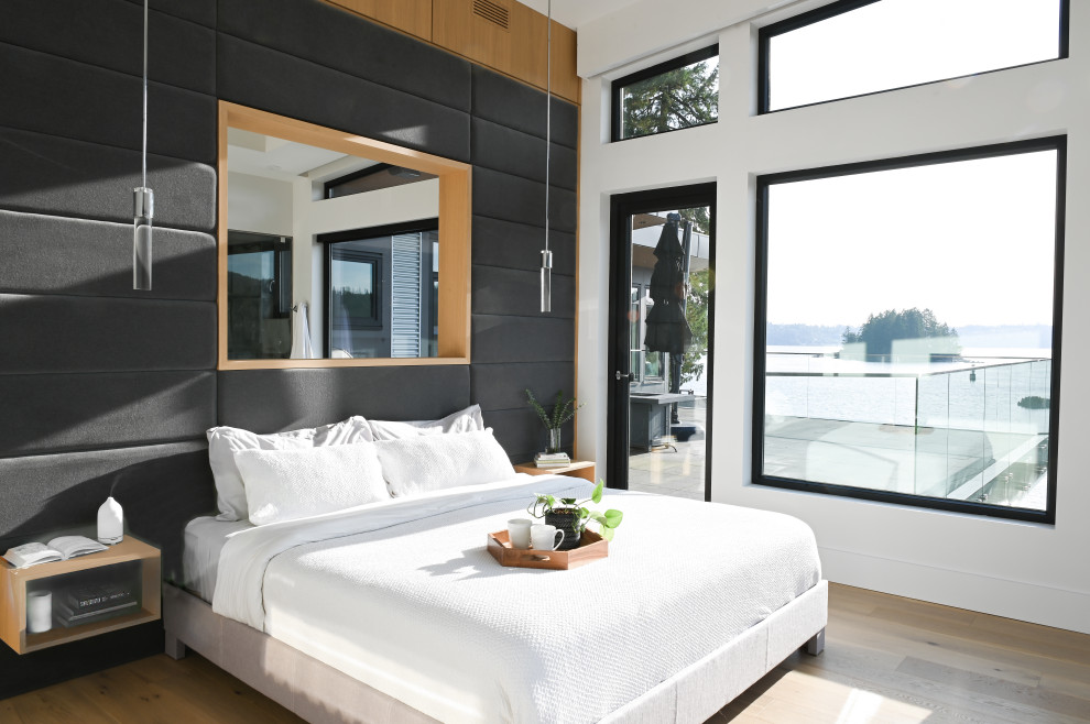Пример оригинального дизайна: хозяйская спальня в современном стиле с белыми стенами, светлым паркетным полом и панелями на части стены