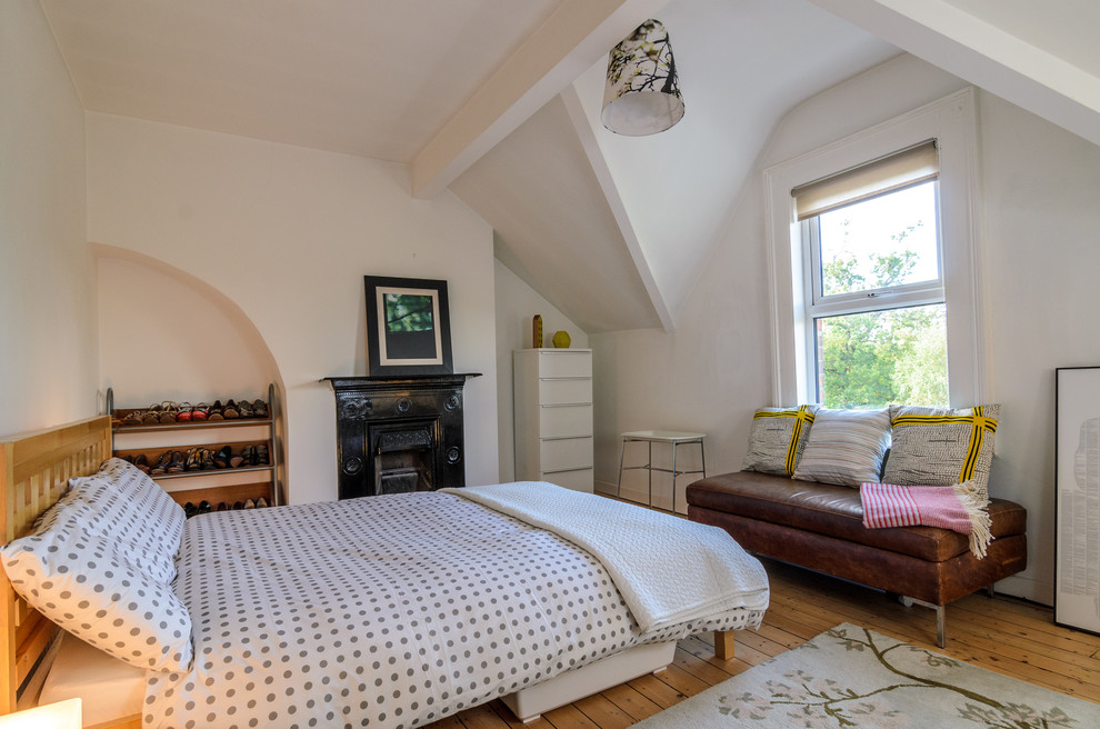 Bild på ett eklektiskt sovrum, med vita väggar och mellanmörkt trägolv