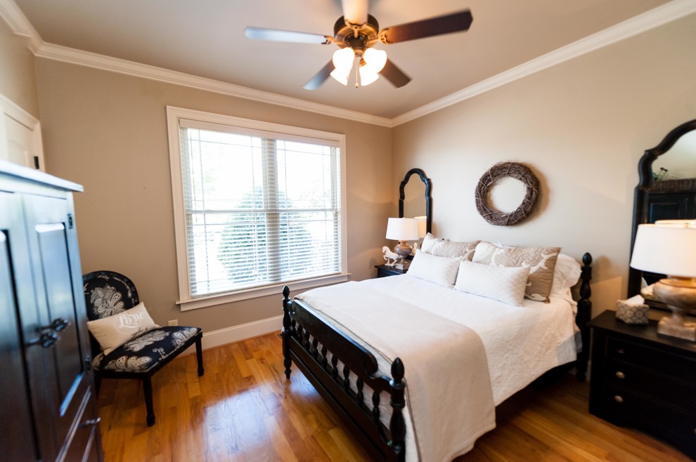 Cette image montre une chambre d'amis craftsman de taille moyenne avec un mur beige et parquet clair.