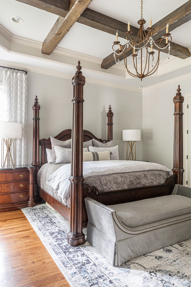 Esempio di una camera da letto con pareti grigie, pavimento in legno massello medio, pavimento marrone, travi a vista e soffitto ribassato