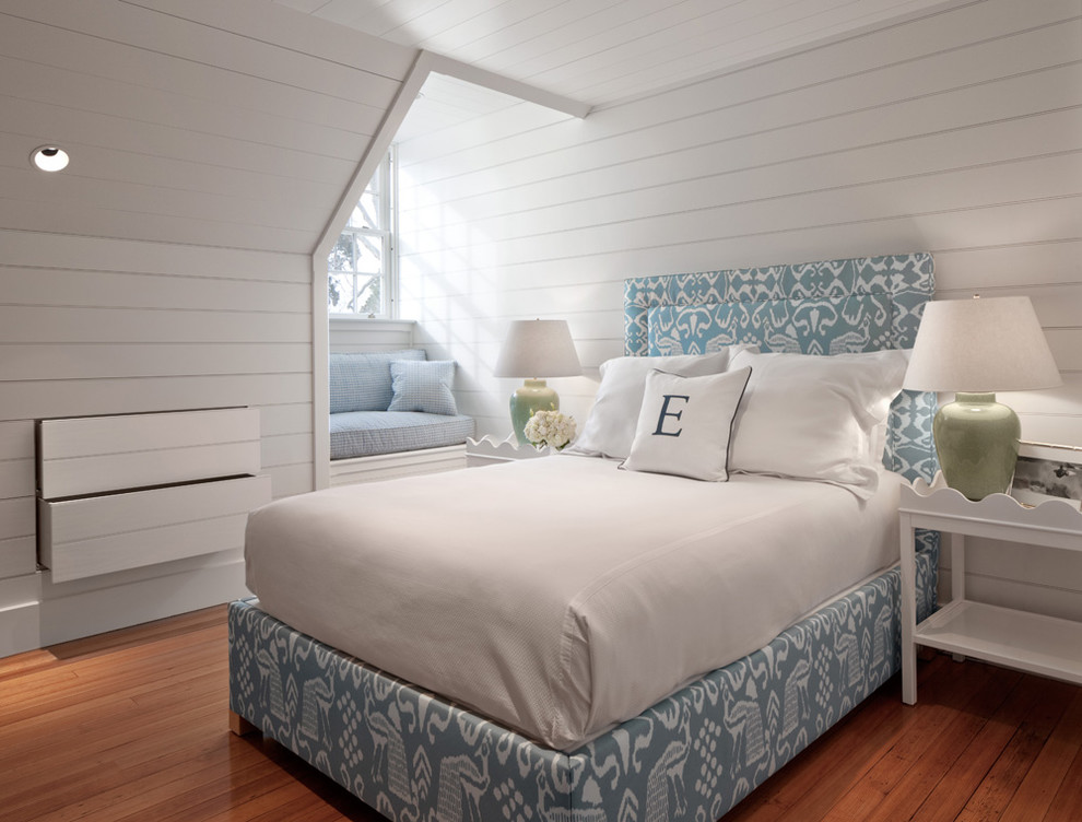Bild på ett maritimt sovrum, med vita väggar och mellanmörkt trägolv