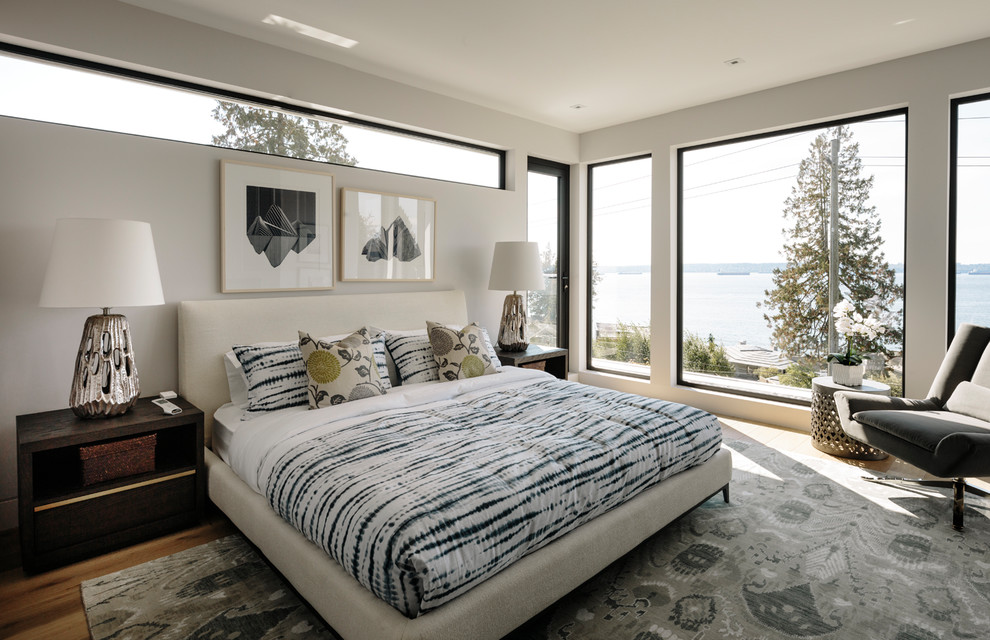 Großes Modernes Hauptschlafzimmer mit weißer Wandfarbe, braunem Holzboden und braunem Boden in Vancouver