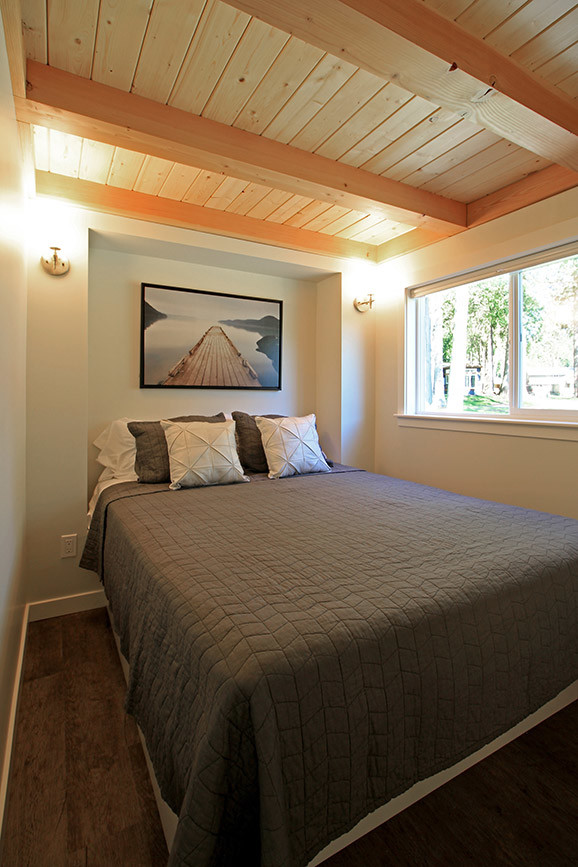Esempio di una piccola camera da letto american style con pareti grigie, pavimento in vinile e nessun camino
