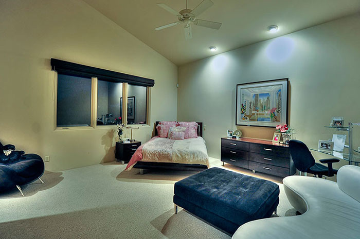 Diseño de habitación de invitados actual extra grande sin chimenea con paredes beige y suelo de travertino