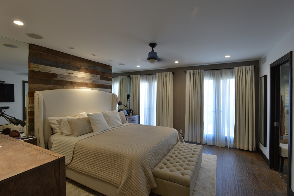 Réalisation d'une grande chambre parentale minimaliste avec un mur blanc, un sol en bois brun et un sol marron.