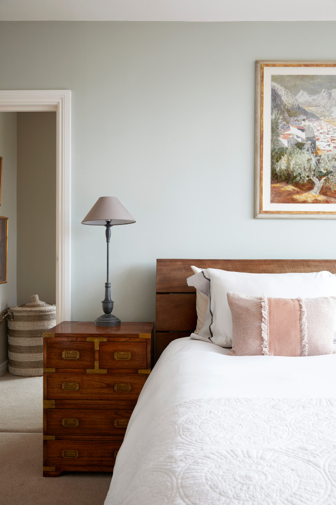 Modelo de dormitorio principal actual pequeño con paredes verdes, moqueta, suelo beige y papel pintado