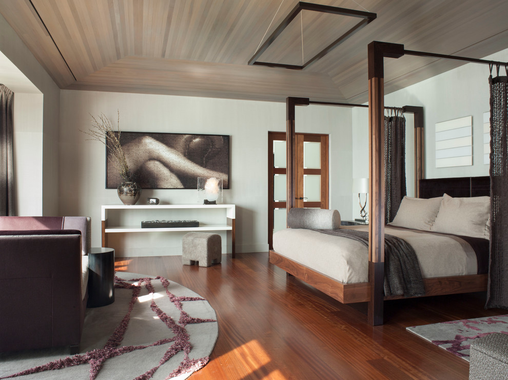 Cette photo montre une chambre tendance avec un mur blanc et un sol en bois brun.