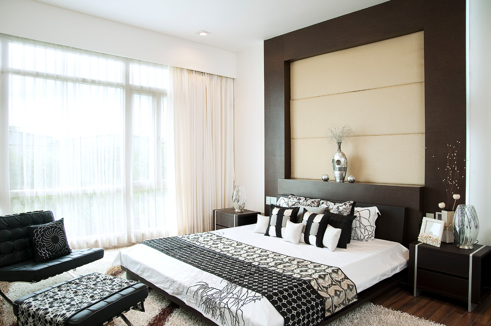 Cette photo montre une chambre parentale tendance de taille moyenne avec un mur blanc et un sol en bois brun.