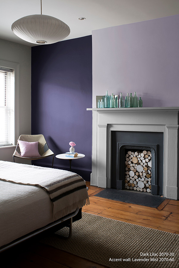 Cette photo montre une chambre chic avec un mur bleu, un sol en bois brun, une cheminée standard et un manteau de cheminée en métal.