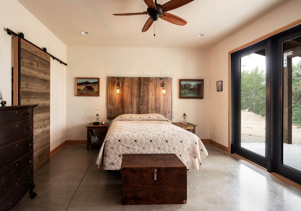 На фото: хозяйская спальня среднего размера в стиле рустика с белыми стенами, бетонным полом и серым полом с