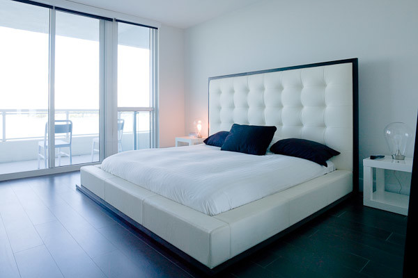 На фото: хозяйская спальня среднего размера в современном стиле с белыми стенами и темным паркетным полом с