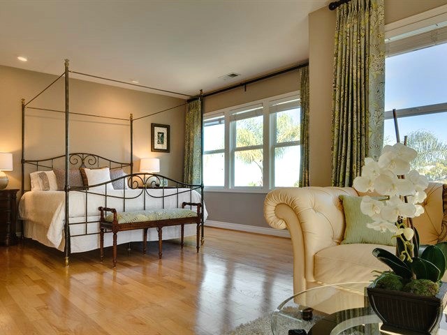На фото: огромная хозяйская спальня в стиле неоклассика (современная классика) с серыми стенами, светлым паркетным полом, стандартным камином и фасадом камина из камня с