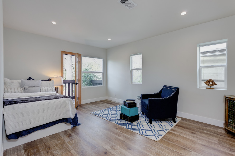 Design ideas for a medium sized contemporary guest bedroom in Los Angeles with white walls and light hardwood flooring.