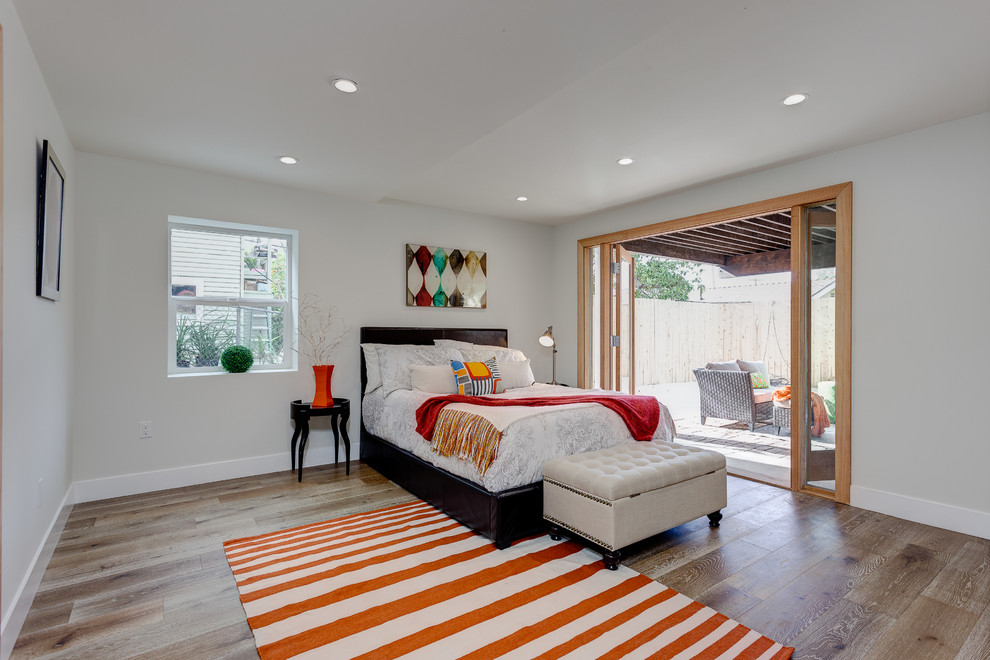 ロサンゼルスにある中くらいなトランジショナルスタイルのおしゃれな主寝室 (淡色無垢フローリング、白い壁)