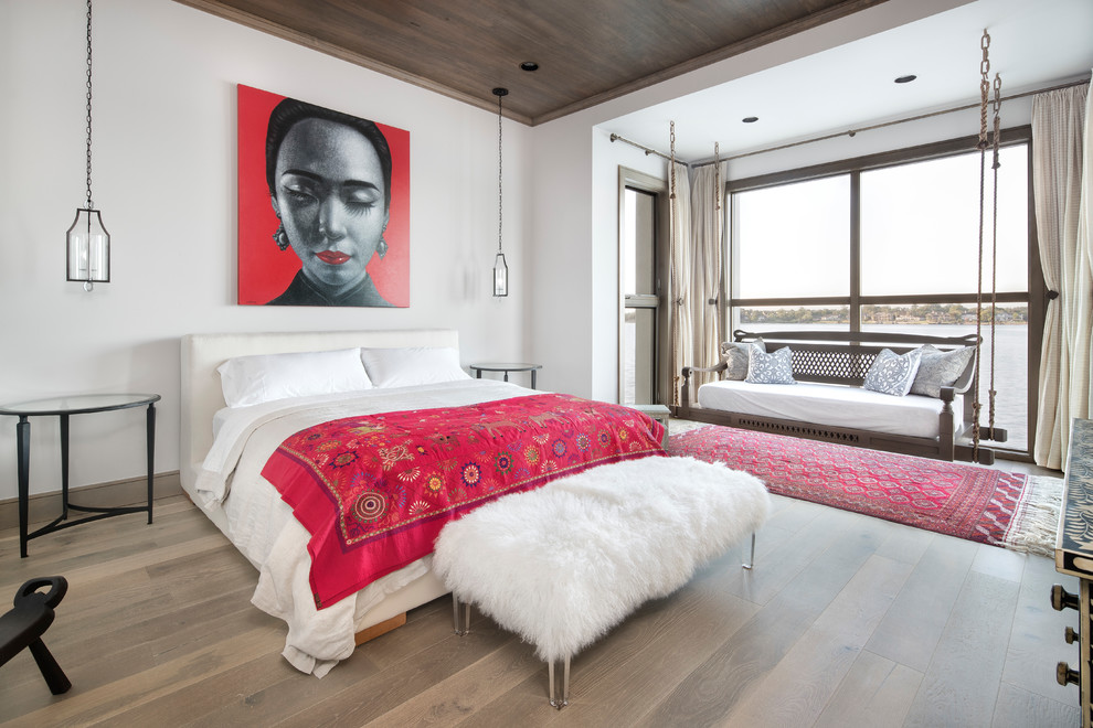 Zen guest medium tone wood floor and brown floor bedroom photo in Houston with white walls