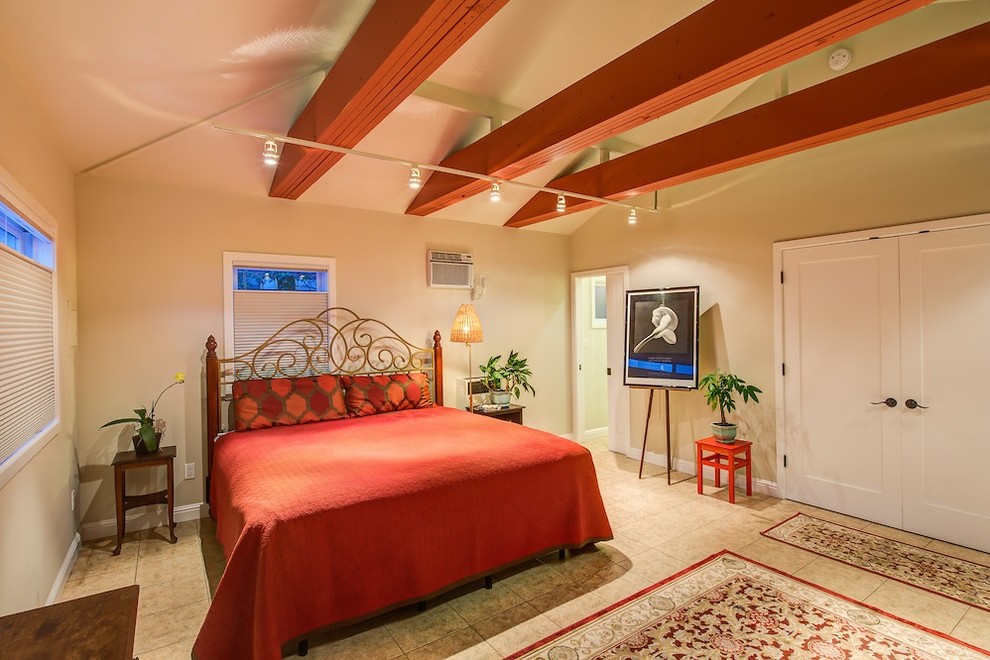 Diseño de dormitorio principal clásico grande sin chimenea con paredes beige, suelo de baldosas de porcelana y suelo beige