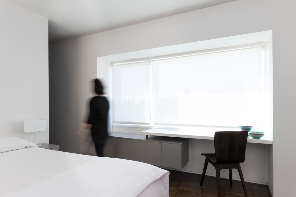 На фото: хозяйская спальня среднего размера в стиле модернизм с белыми стенами и темным паркетным полом без камина