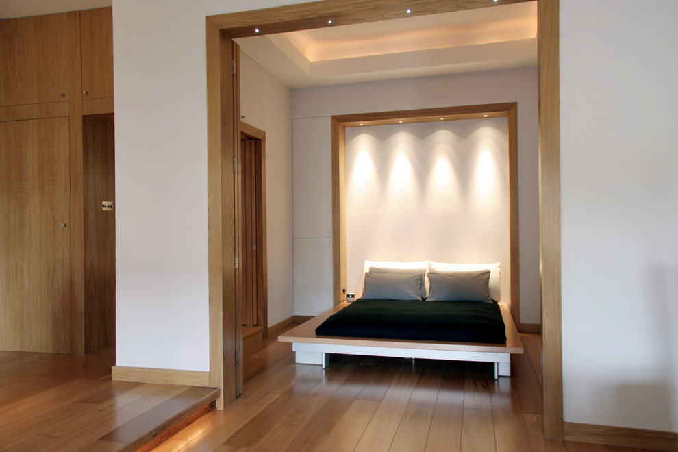 Mittelgroßes Modernes Hauptschlafzimmer mit weißer Wandfarbe, hellem Holzboden und braunem Boden in London