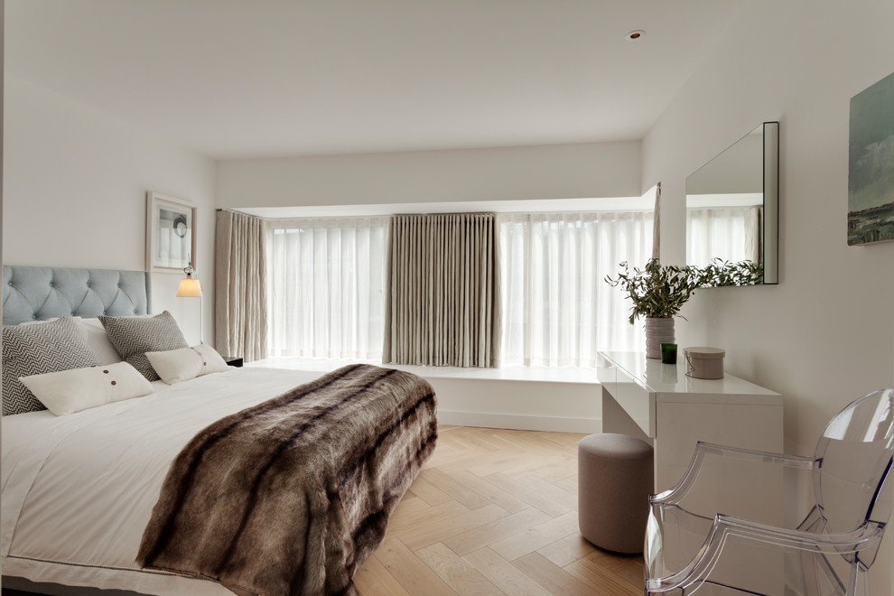 Inspiration for a medium sized modern guest bedroom in London with white walls, light hardwood flooring and beige floors.