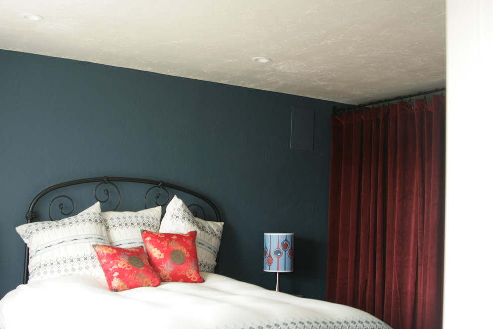 Diseño de dormitorio principal moderno sin chimenea con paredes azules