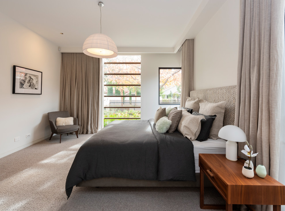 Modernes Hauptschlafzimmer mit weißer Wandfarbe, Teppichboden und buntem Boden in Melbourne