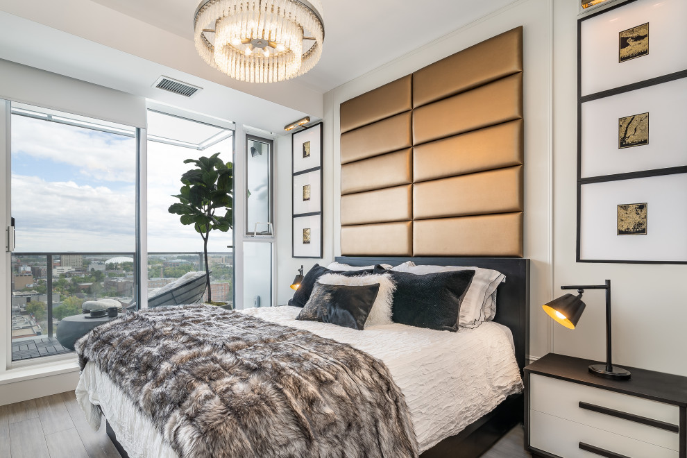 Diseño de dormitorio principal actual pequeño con paredes grises, suelo de madera clara, suelo gris y panelado