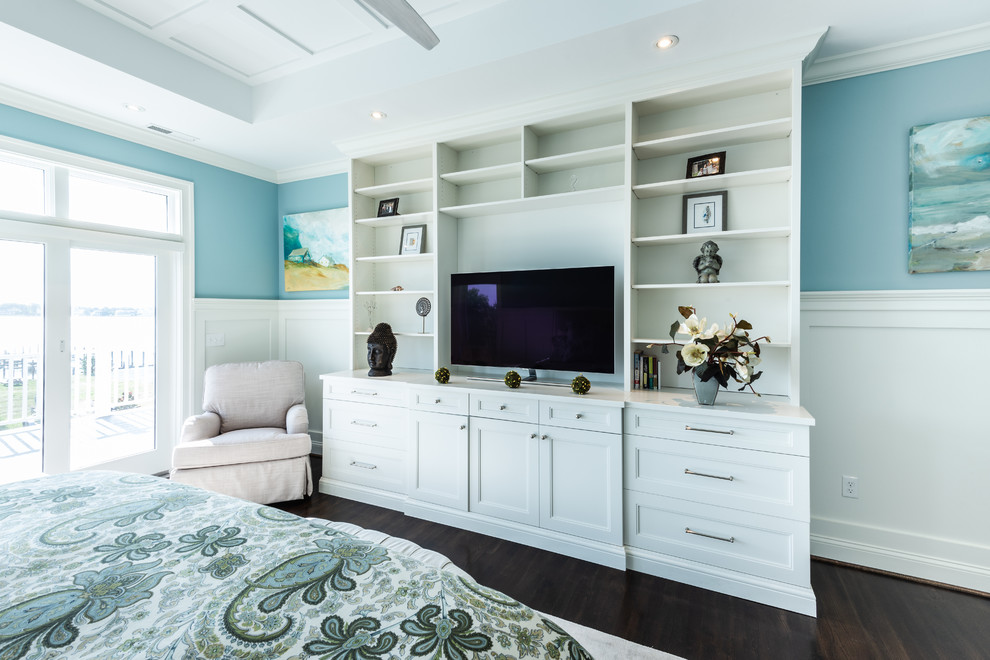 Imagen de dormitorio principal costero de tamaño medio sin chimenea con paredes azules, suelo de madera clara y suelo marrón
