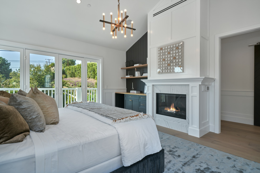 ロサンゼルスにある広いコンテンポラリースタイルのおしゃれな主寝室 (白い壁、無垢フローリング、標準型暖炉、石材の暖炉まわり、茶色い床、羽目板の壁)