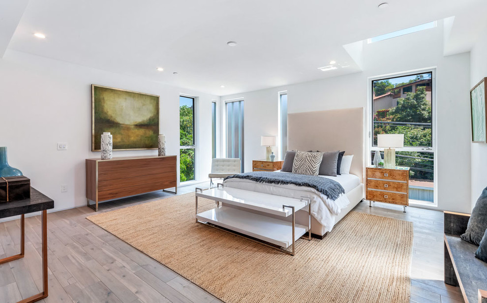 Modernes Schlafzimmer mit weißer Wandfarbe, hellem Holzboden und grauem Boden in Los Angeles