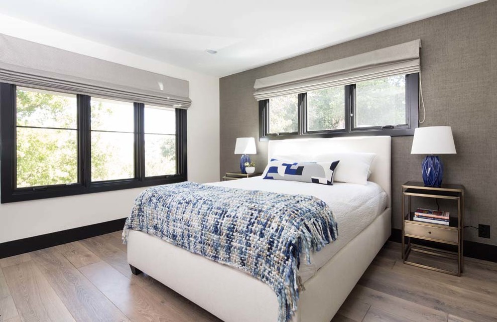 Imagen de habitación de invitados actual de tamaño medio con paredes grises, suelo de madera en tonos medios y suelo gris