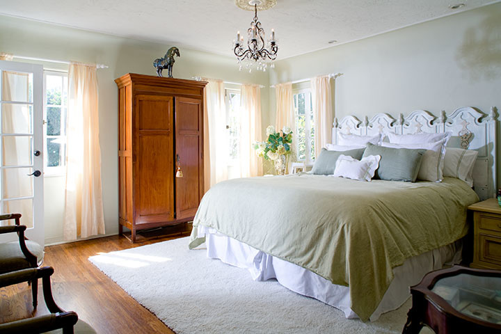 Foto de dormitorio principal tradicional renovado de tamaño medio con paredes blancas y suelo de madera en tonos medios
