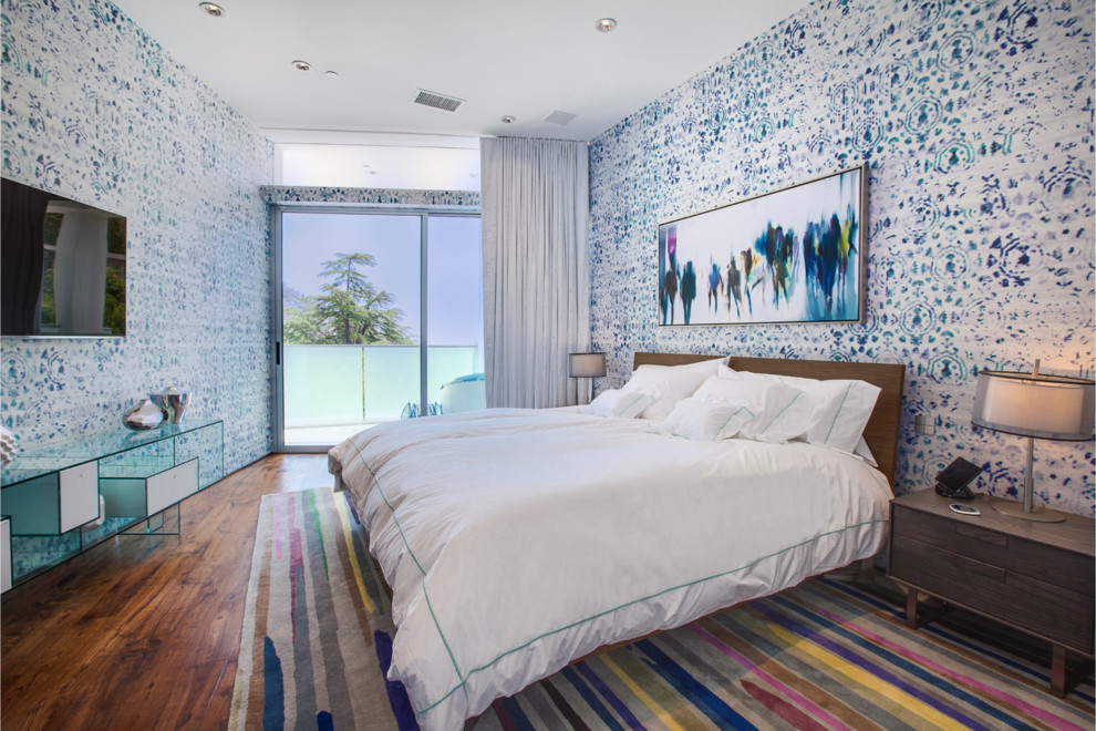 This is an example of a large contemporary master bedroom in Los Angeles with no fireplace, multi-coloured walls and medium hardwood flooring.