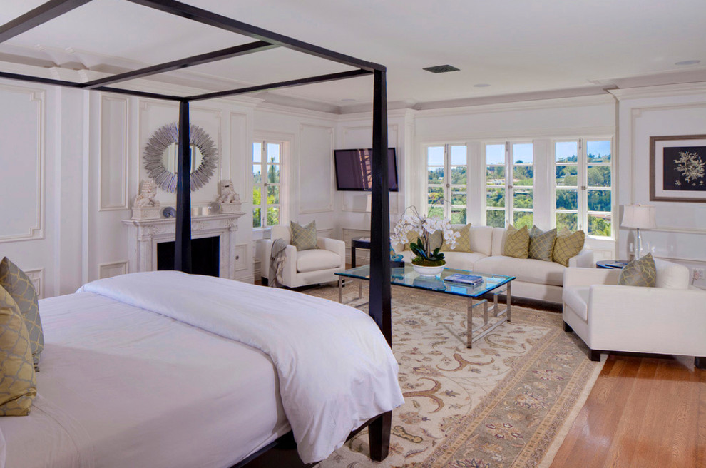 Пример оригинального дизайна: большая хозяйская спальня в классическом стиле с белыми стенами, паркетным полом среднего тона, стандартным камином, фасадом камина из камня и коричневым полом