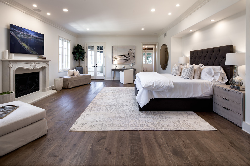 ロサンゼルスにある地中海スタイルのおしゃれな主寝室 (濃色無垢フローリング、コンクリートの暖炉まわり、茶色い床) のインテリア