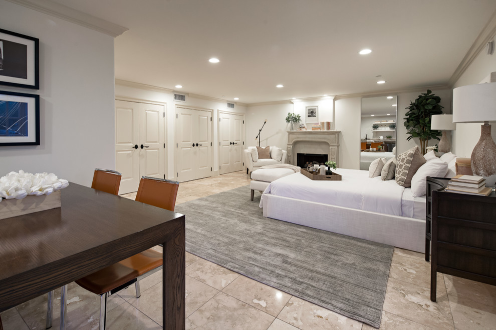 Mediterranes Gästezimmer mit Kamin, Kaminumrandung aus Beton und braunem Boden in Los Angeles