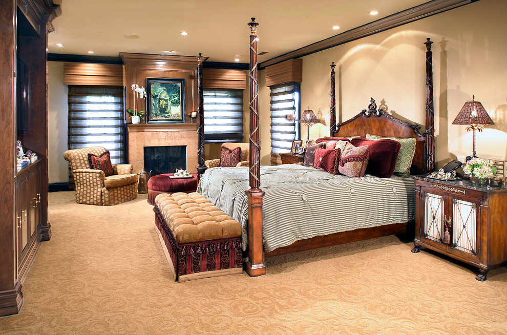 Example of a tuscan master carpeted bedroom design in Los Angeles with beige walls, a standard fireplace and a tile fireplace