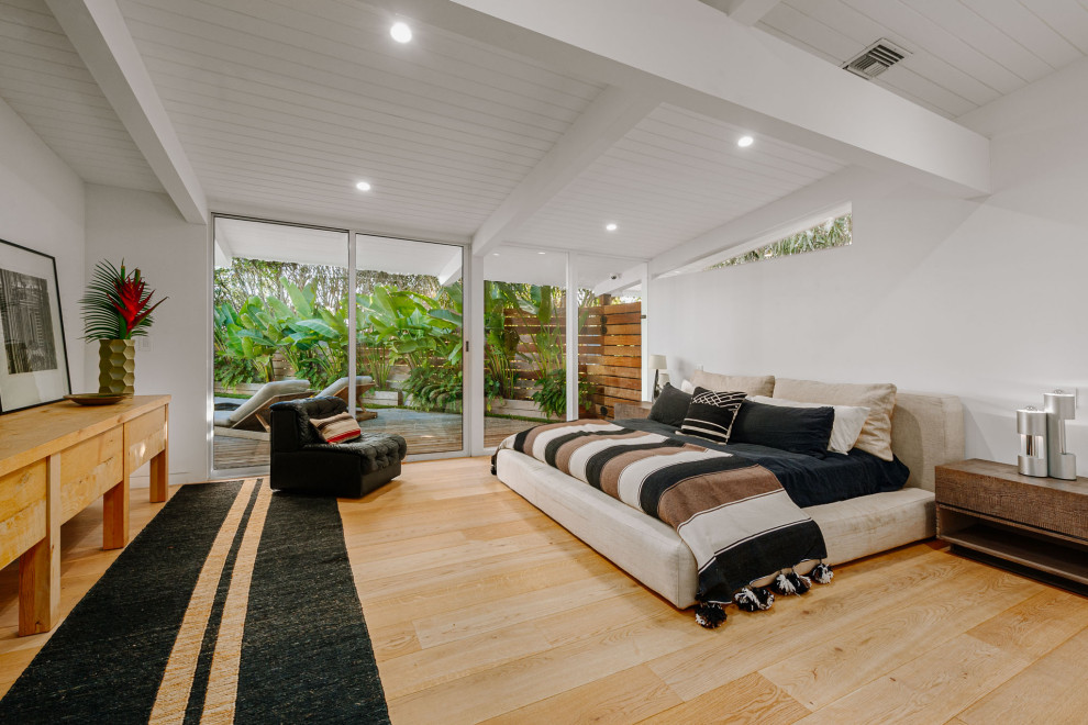 Großes Retro Hauptschlafzimmer mit weißer Wandfarbe, hellem Holzboden und beigem Boden in Los Angeles