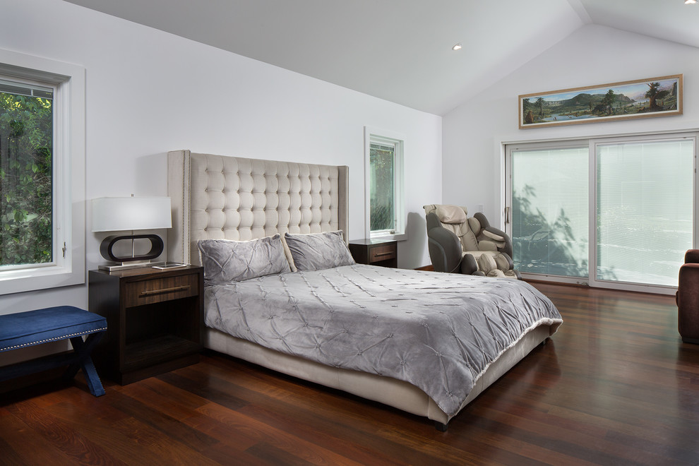 Modelo de dormitorio principal contemporáneo de tamaño medio sin chimenea con suelo de madera oscura, paredes blancas y suelo marrón