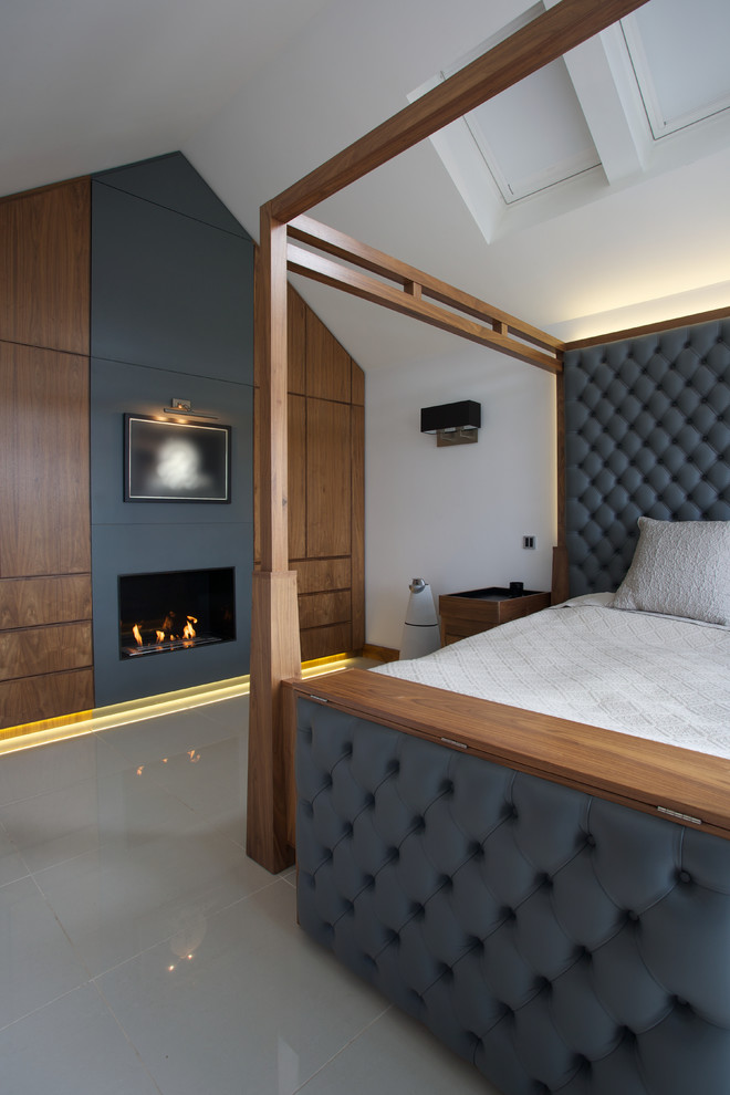 Modernes Hauptschlafzimmer mit weißer Wandfarbe und Kamin in London