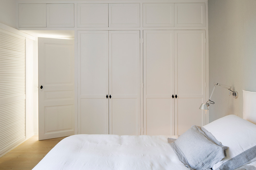 Diseño de dormitorio principal actual de tamaño medio con paredes grises, suelo de madera clara y suelo beige