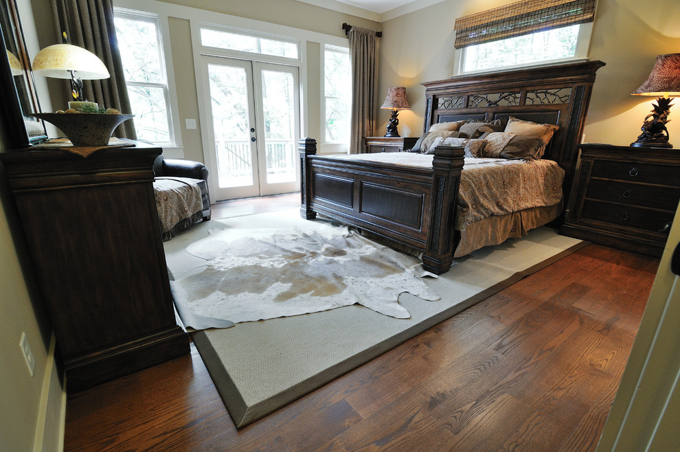 Cette image montre une chambre parentale traditionnelle de taille moyenne avec un mur beige, un sol en bois brun et aucune cheminée.